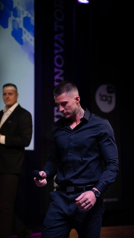 Pranešėjas scenoje su mikrofonu